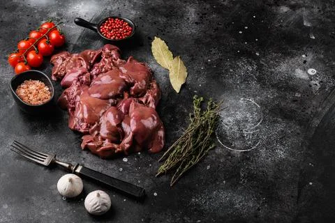 Fresh chicken liver and ingredients, on black dark stone table background, wi Stock Photos