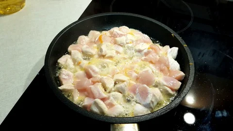 Fresh chicken meat cut into cubes fried in a frying pan Stock Footage 127776218