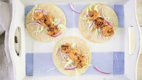 Fresh chipotle shrimp tacos with cotija cheese on a white corn tortillas. Stock Footage