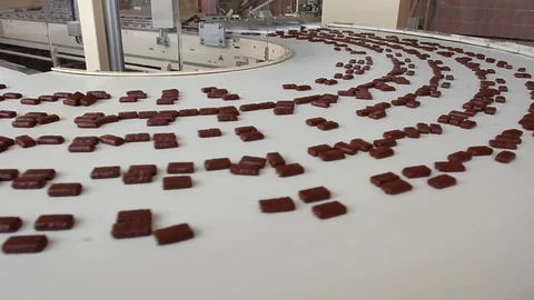 Fresh chocolates go down the conveyor. Chocolate Factory. Production of 库存影片 102230980