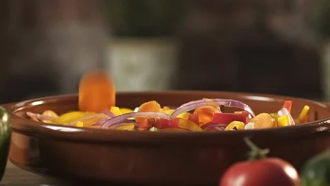 Fresh chopped vegetables falling in a bowl Stock Footage 128689439
