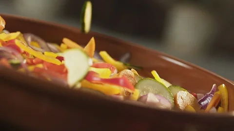 Fresh chopped vegetables falling in a bowl Stock Footage 128689482