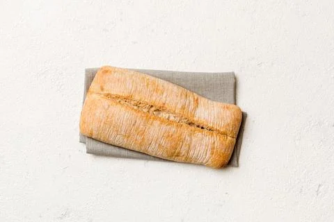 Fresh ciabatta bread on napkin on rustic background, Italian bread top view Stock Photos