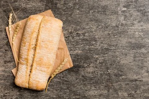 Fresh ciabatta bread on napkin on rustic background, Italian bread top view Stock Photos