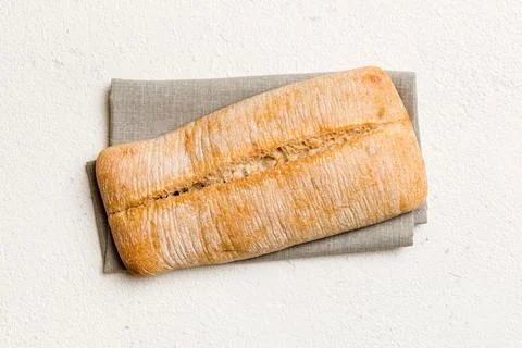 Fresh ciabatta bread on napkin on rustic background, Italian bread top view Stock Photos