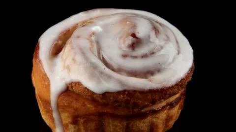 Fresh cinnamon roll coated in icing Stock Footage