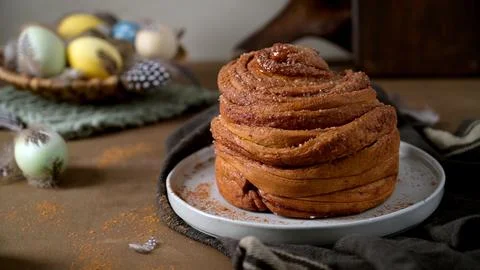 Fresh Cinnamon Roll with Easter Eggs and Spring Decor Stock Photos