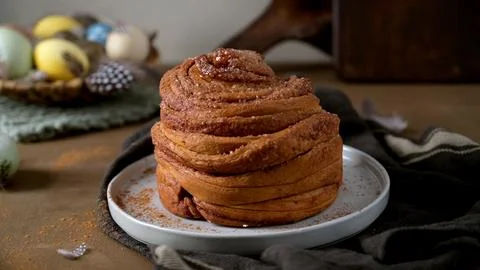 Fresh Cinnamon Roll with Easter Eggs and Spring Decor Stock Photos