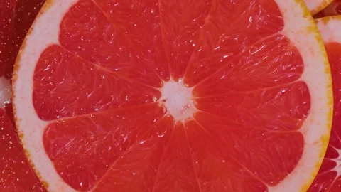 Fresh citrus fruit red slices of grapefruit on rotating surface - close up Stock Footage 340431219