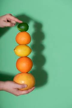 Fresh citrus fruits stack in hand. Summer fruits column Stock Photos