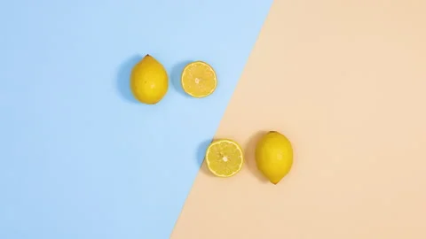 Fresh citrus lemons make creative layout on blue sandy background. Stop motion Stock Footage 151935632