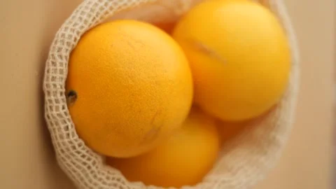 Fresh citrus oranges in eco friendly cotton mesh bag hanging on wall for ze.. Vídeos de archivo 332116560