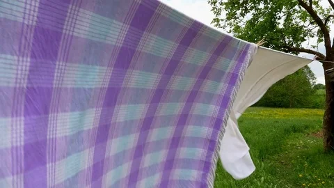 Fresh clean sheets drying on washing line outdoors on windy day slow motion Video stock 77306281