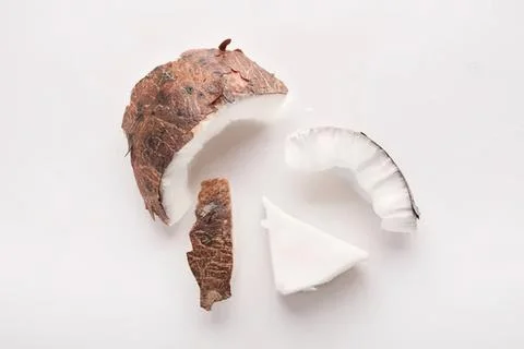 Fresh coconut with brown shell and white flesh on white background Фото