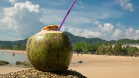 Fresh coconut with drinking straw on tropical beach, Time Lapse Stock Footage 63314110
