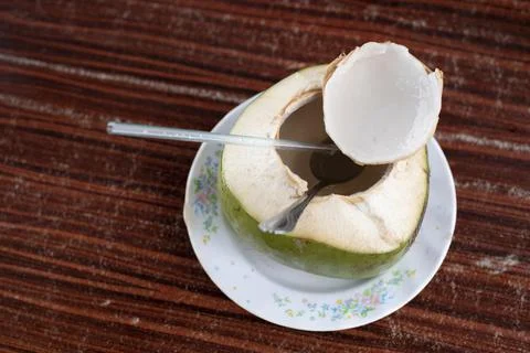 Fresh coconut fruit drink on a table with drinking straw. Stock Photos