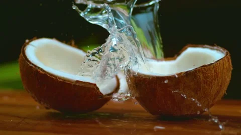 Fresh coconuts splashing with water on table Stock-Footage 158002915