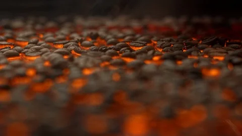 Fresh coffe beans falling down in slow motion on roasting platform with smoke Video stock 129493664