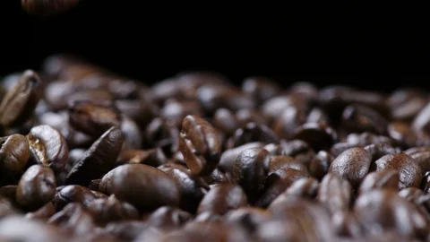 Fresh coffee beans falling into a basket in slowmotion Stock Footage 99059952