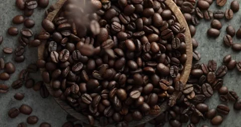 Fresh coffee beans falling in slow motion onto a wooden plate. 動画素材 167132770