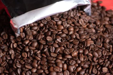 Fresh coffee beans on red background. Dark fresh roast coffee bean on red woo Stock Photos