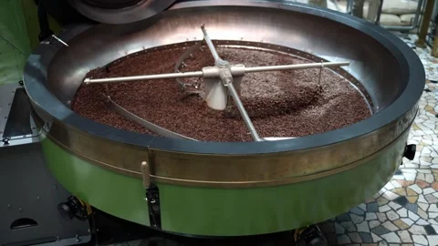 Fresh coffee beans spin slowly in a polished cooling drum with vintage green cas Stock Footage 310055882