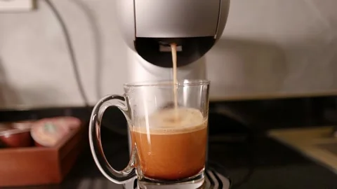 Fresh Coffee Pouring from Espresso Capsule Machine into Glass Mug Stock Footage 346270557