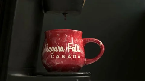 Fresh coffee pouring from machine into a red cup Stock Footage 200812867
