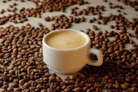 Fresh coffee surrounded by aromatic roasted beans on a quiet morning Foto stock
