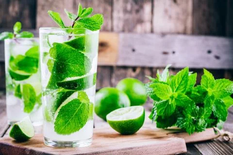 Fresh cold lemonade with lime, mint and ice in glass Stock Photos