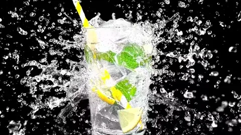 Fresh cold mojito cocktail drink with ice lime and mint leaves splashing in Stock Footage 340952644