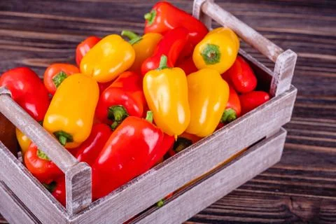 Fresh colored bell peppers on a rustic wooden background. Foto stock