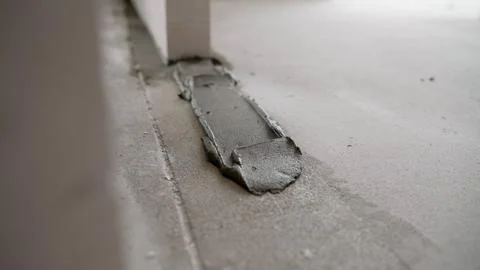 Fresh concrete patch on floor with trowel mark and soft lighting Stockfoto's