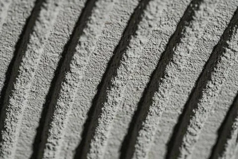 Fresh concrete tehture with patterns of notched trowel. Macro shot of grey Stock Photos