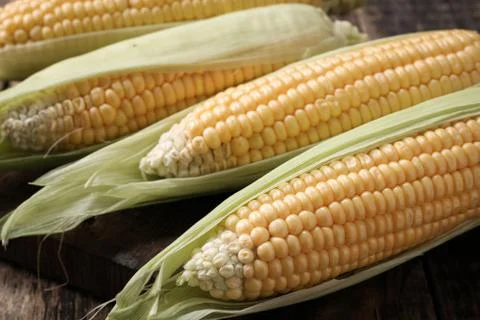 Fresh corn on cobs on rustic wooden table, closeup Stock Photos