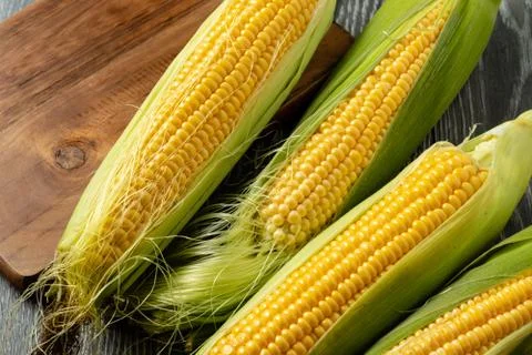 Fresh corn on cobs on rustic wooden table, closeup Stock Photos