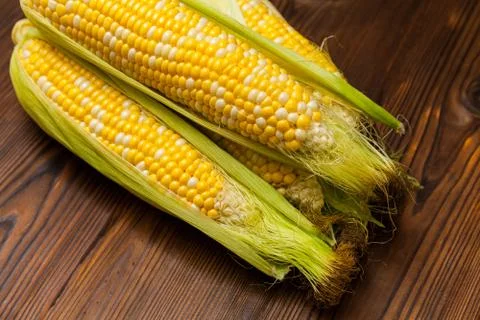 Fresh corn on cobs on rustic wooden table, closeup Stock Photos
