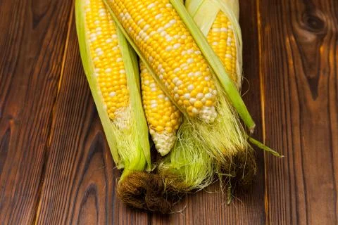 Fresh corn on cobs on rustic wooden table, closeup Stock Photos