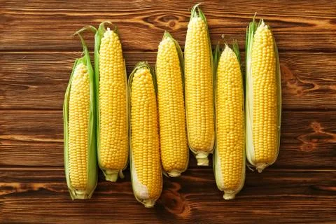 Fresh corn on cobs on rustic wooden table. Summer healthy vegetables. Top vie Stock Photos