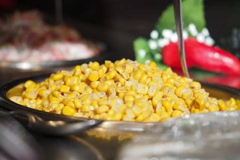 Fresh corn in a serving dish at a meal setting Stock Photos