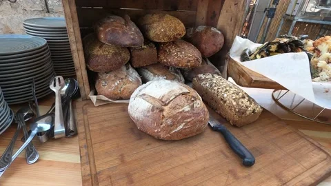 Fresh crispy delicious bread lies in open box and on wood cutting board. Stock Footage 199034507