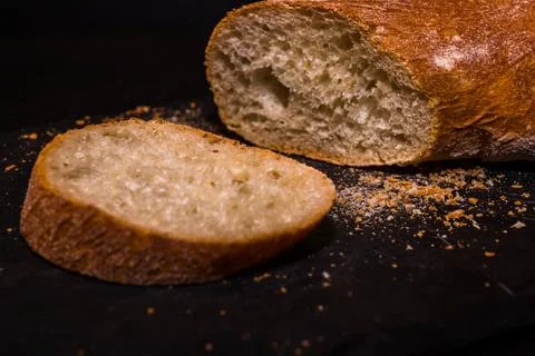 Fresh crispy sliced bread on a black background with copy space. Stock Photos