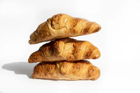 Fresh croissants in a stack on a white background. Homemade cakes, fresh bread Stock Photos