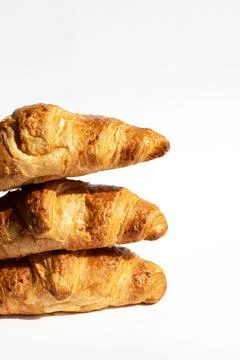 Fresh croissants in a stack on a white background. Homemade cakes, fresh bread Foto stock