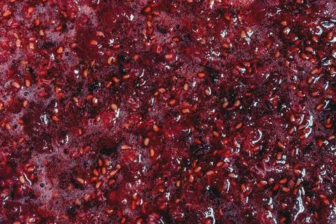 Fresh crushed raspberry pulp texture with seeds and glossy juice Foto stock