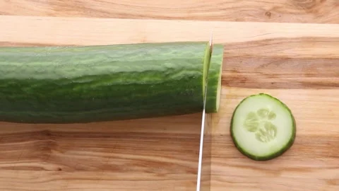 Fresh Cucumber Being Sliced Into Thin Rounds on Wooden Board Stock Footage 308466569
