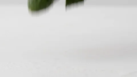 Fresh cucumber is broken into pieces while falling on a wet surface in slow Stock Footage 92914866