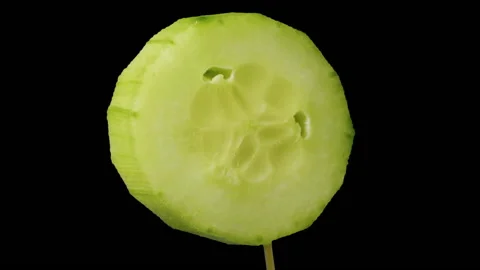 Fresh cucumber slice rotates isolated on black. Stock Footage 170828905
