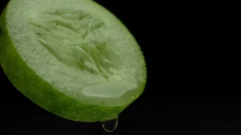 Fresh cucumber slice with water drops, isolated on black background Stock Footage 236590960