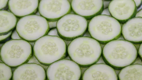 Fresh cucumber slices pattern display. Tightly arranged thin cucumber slices wit Stock Footage 332785103